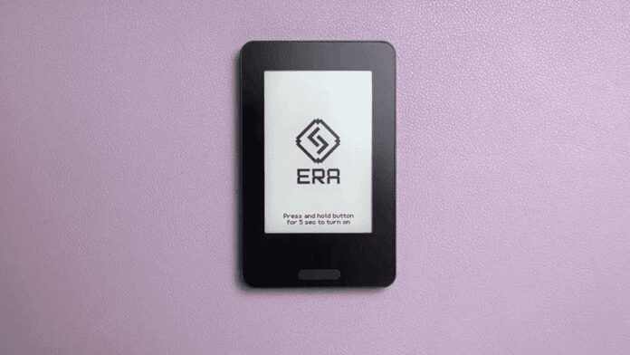 Front of Era hardware wallet placed on a purple surface showing ERA logo on the screen