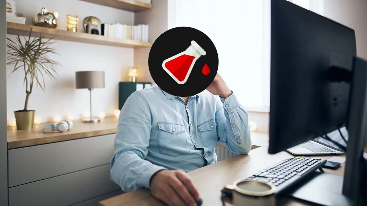 person working at desk with computer and keyboard (face obscured)