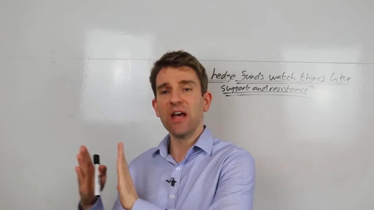 Presenter gesturing with both hands holding a marker in front of a whiteboard that reads 'Do hedge funds watch things like support and resistance?'