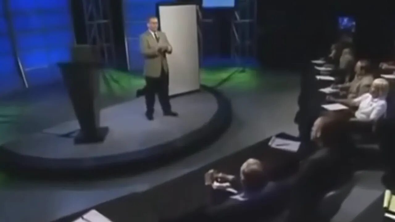 Instructor on stage addressing an audience in a seminar-style studio